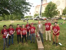 Professors and students stand in front of the Basilica of the National Shrine of the Immaculate Conception at The Catholic University of America's campus, to begin building truss number six of Notre Dame Cathedral in France.
